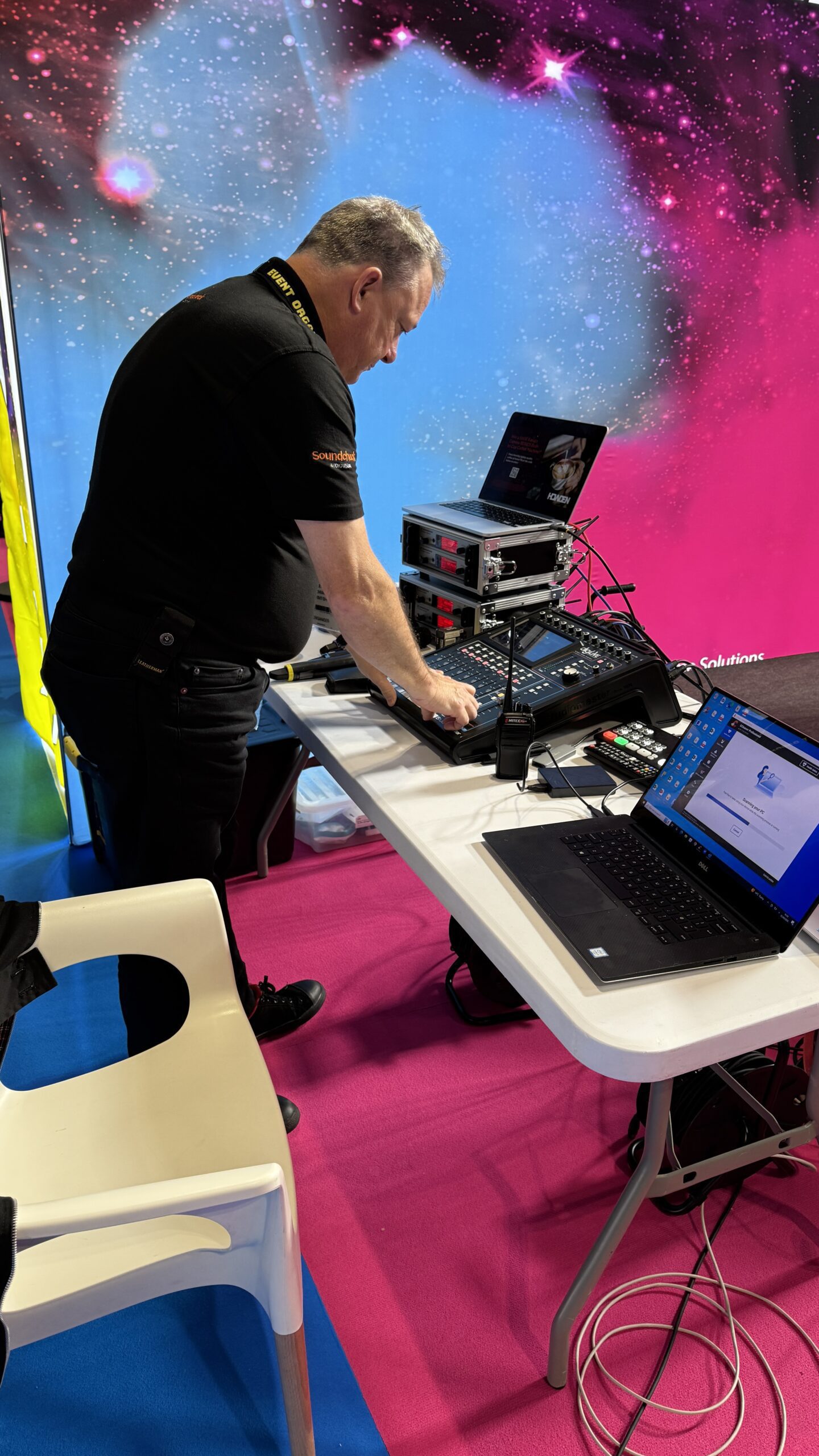 Andrew Lake working at the mixing desk at The Print Show, wearing an Event Crew lanyard